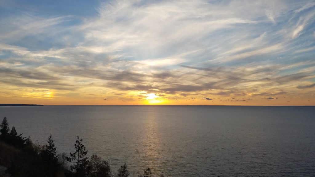 Sun setting into the Lake Michigan, and two sundogs at 22 degrees left and right from the Sun.